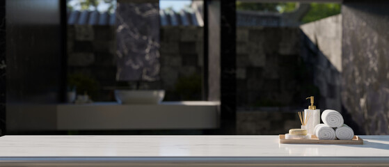 Empty space on white tabletop with bath accessories over blurred modern outdoor bathroom.