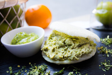 Pulled chicken avocado arepa. The arepa is a food of pre-Columbian origin, made from ground dry corn dough or precooked cornmeal, circular and flattened.
