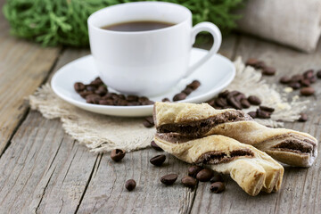 Cup of coffee with chocolate chip cookie on wooden background