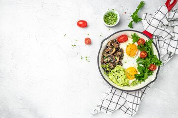 Breakfast skillet pan of fried egg, avocado and mushrooms. Ketogenic diet. Low carb high fat breakfast. Healthy food concept. place for text, top view