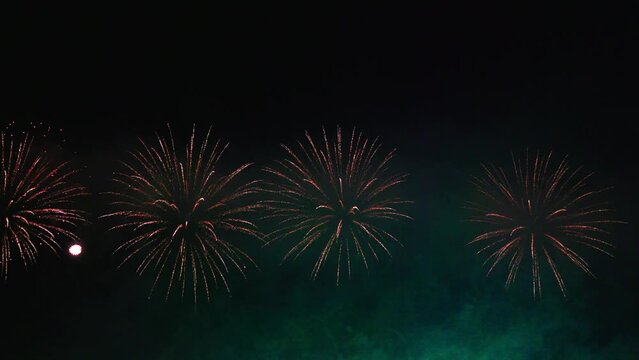 Colorful huge fireworks. Beautiful holiday fireworks in slow motion. Wonderful real fireworks in the night sky shot with a telephoto lens. fireworks show. 4K slow motion video.