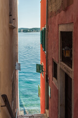 One of the narrow streets with colorful houses leading to the Adriatic Sea
