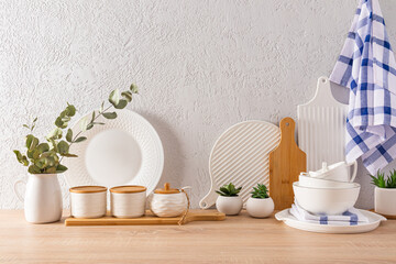 beautiful kitchen background with various kitchen utensils, textiles for the kitchen. wooden table top, gray textured background with space for text.
