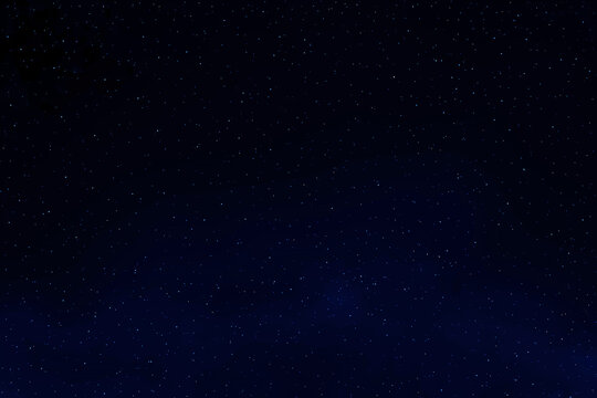 Dark blue galaxy space background.  Starry night sky.  Glowing stars in space.