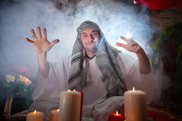 Arab sheikh in white robe and headscarf in boudoir in room with red carpet and candles with smoke....