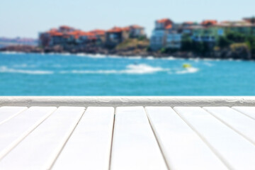Plank wooden surface against defocused blue sea background