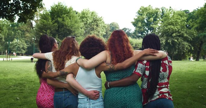 Back View of Diverse Female Friends Walking in the Park While Embracing Each Other, Talking and Laughing. a Group of Multiethnic Young Women Having Fun and Enjoying Summer Weather