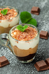 Dessert three chocolate in a glass jar on a wooden board. Food recipe background. Close up