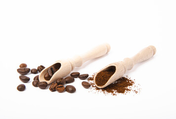 Ground coffee and beans in wooden spoons isolated on white background.