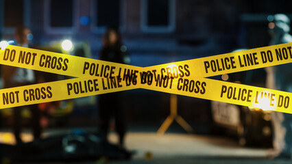 Restricted Area: Yellow Tape Showing Text "Police Line Do Not Cross". Blurred Background with Crime Scene Investigation Squad Working on a Murder Case at Night. Cinematic Aesthetic Shot