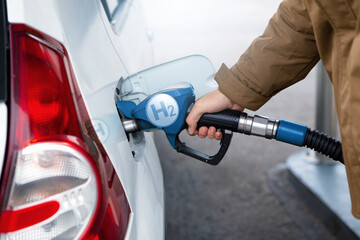 A man fuels a car with hydrogen. Clean transportation concept