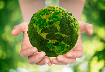 A man is holding a green planet Earth. Symbol of sustainable development and renewable energy
