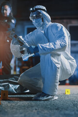 Low, Ground Level Shot: Forensics in Coverall Suit Walking Towards Evidence on a Crime Scene and...