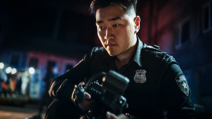 Close Up Shot: Asian Male Police Officer Taking Photos on a Crime Scene at Night. Professional...