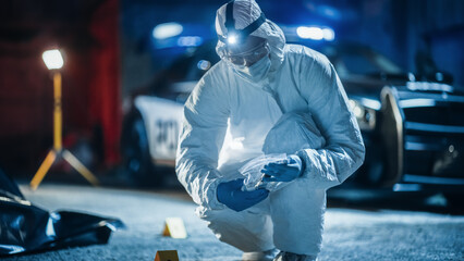 Portrait of Two Forensics Experts Doing Fieldwork at Night at a Crime Scene. One Technician Packs the Bloodied Knife as Murder Weapon While the Other is Taking Photos of the Dead Body. - obrazy, fototapety, plakaty