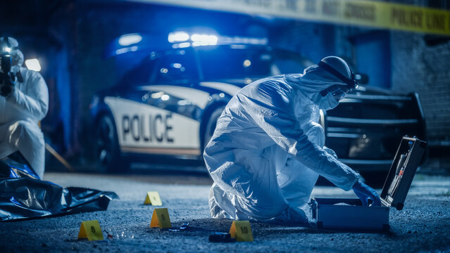 Crime Scene Investigation Team Working on a New Murder Case. Forensics Expert Using Equipment to Properly Package a Bloodied Knife in a Plastic Bag. Shocking Case of Street Violence Incident