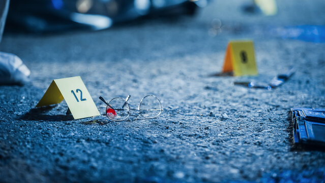 Close Up Low Angle Shot of Evidence Scattered at Crime Scene. Bloodied Glasses, Bloody Knife and Empty Wallet, all Marked as Clues in a Murder Investigation. Aesthetic True Crime Footage