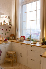 Vertical photo of new cozy kitchen with modern interior, wooden cabinets, countertop, hood hob over...