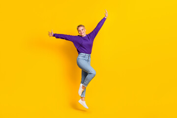 Fototapeta na wymiar Full body photo of satisfied glad lady jumping good mood raise arms isolated on yellow color background