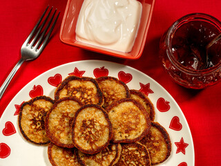 Rye pancakes served with sour cream and strawberry jam