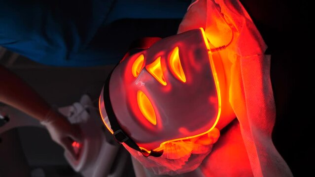 LED light anti-aging mask for facial skin care in beauty clinic. Modern technologies in beauty salon. Woman having led therapy for face skin regeneration. acne treatment in beauty salon. 4 k video