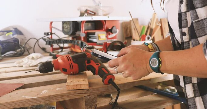 Carpenter woman using mobile phone, close-up 4k video