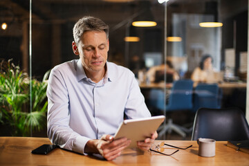 Portrait of businessman in office. Man using digital tablet. Businessman having video call.