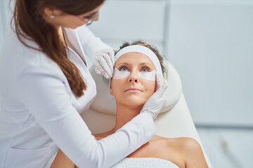 Fototapeta na wymiar Woman having cosmetology eyebrows treatment in beauty salon