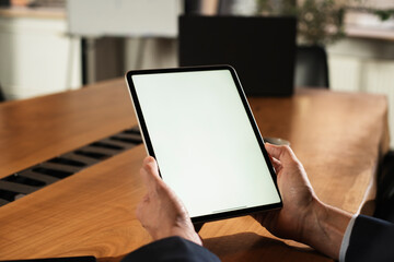 Close up of man using digital tablet. Man holding tablet in office