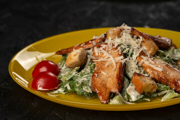 Grilled chicken breast with vegetables and herbs . Caesar salad