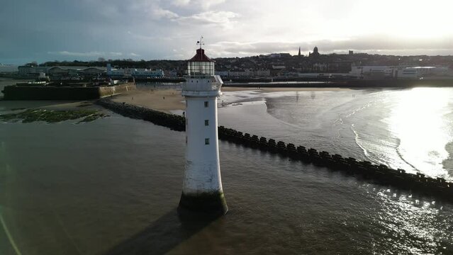 New Brighton Perch Rock Lighthouse, River Mersey, Wirral -  aerial drone close clockwise pan, New Brighton waterfront reveal on a sunny winter afternoon 08.01.23