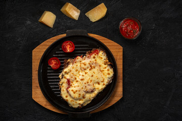 Grilled meat baked with cheese and tomatoes