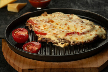 Grilled meat baked with cheese and tomatoes