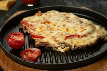 Grilled meat baked with cheese and tomatoes