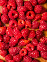 Fresh raw raspberry on wooden board and white isolated background. Fruit product for sale.