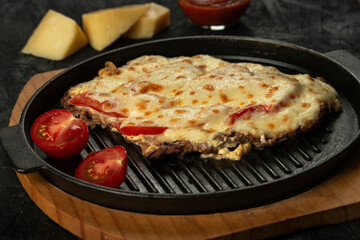 Grilled meat baked with cheese and tomatoes