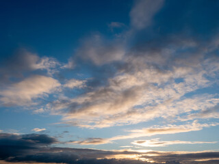 Beautiful cloudy sky with rich blue color at sunset. Nature background for design and sky replacement.