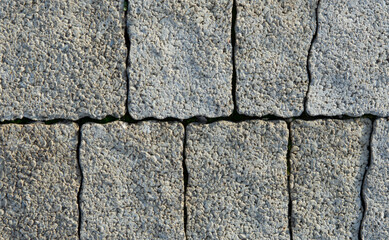 Rectangular dark gray blocks stacked vertically and in rows with porous texture