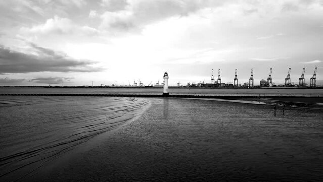 New Brighton Perch Rock Lighthouse, River Mersey, Wirral -  aerial drone low approach, Liverpool waterfront backdrop on a sunny winter afternoon (noir LUT) 08.01.23