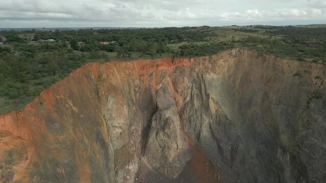 Aerial flight to rock spire deep in Cullinan Diamond Mine big hole pit