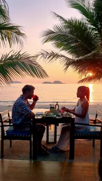 Couple having a Romantic dinner on the beach of Koh Chang in Thailand during sunset, Romantic dinner on the beach in Thailand during sunset