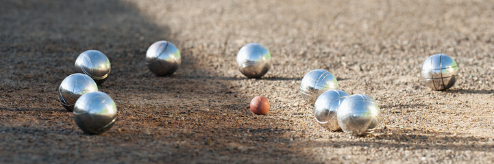 Petanque balls boules bowls on closeup on sand gravel court background, game of petanque on the ground. Balls and a small wood jack