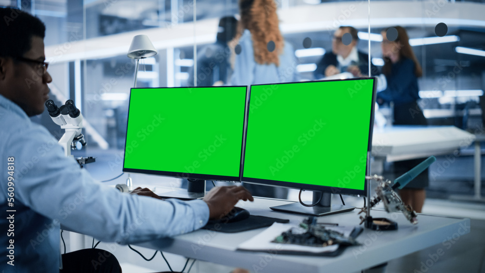 Aufkleber Software Developer Working on Computer with Green Screen Mock Up Display. Scientific Lab, Engineering Research Center with Specialists Working on Mobile Robot Development in the Background.