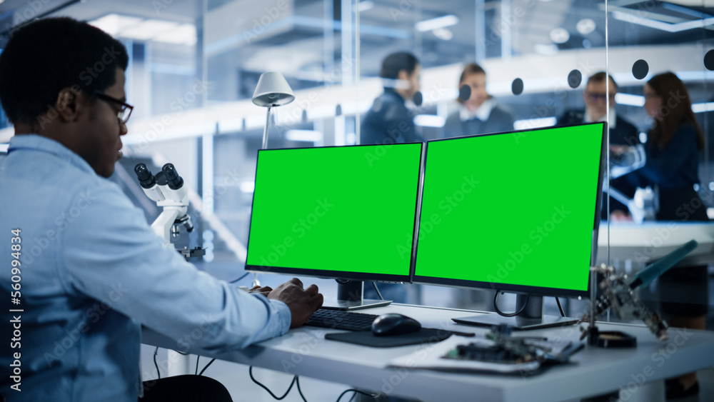 Aufkleber Software Developer Working on Computer with Green Screen Mock Up Display. Scientific Lab, Engineering Research Center with Specialists Working on Mobile Robot Development in the Background.
