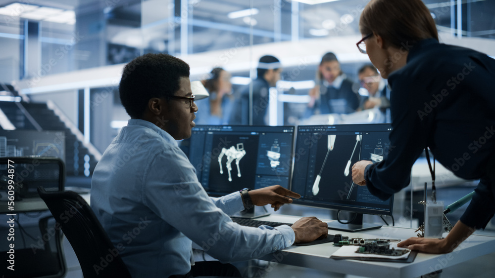 Aufkleber Automation Development Factory: Project Manager and Software Developer Talk, Point at Computer with 3D Robot Dog Model. Engineering Specialists Working on Robot Development in the Background.
