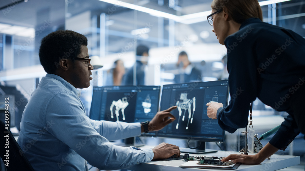 Aufkleber Automation Development Factory: Project Manager and Software Developer Talk, Point at Computer with 3D Robot Dog Model. Engineering Specialists Working on Robot Development in the Background.