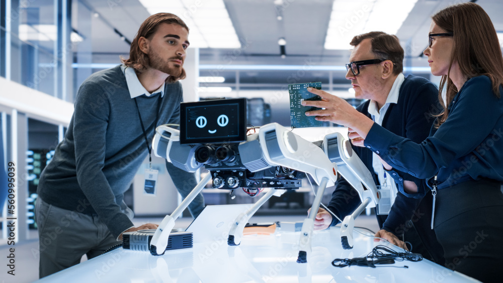 Fototapete Portrait of Diverse International Team of Industrial Robotics Engineers Gathered Around a Table With a Robot Dog. Scientists Use Computers and Connect a Motherboard to a Mobile AI Four-Legged Robot.