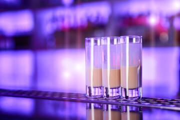A set of two-tone alcohol shots on the bar counter of a nightclub