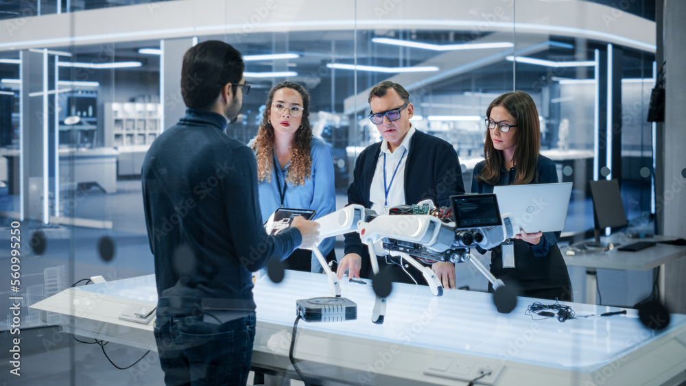 Fototapete Diverse Team of Industrial Robotics Specialists Gathered Around a Table With a Mobile Robot. Scientists Use Tablet and Laptop Computers to Program the Automated AI Robotic Dog.