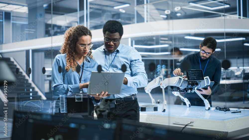 Poster Portrait of Two Multiethnic Female and Male Engineers Use Laptop Computer to Connect, Analyze and Discuss How to Program a Robot Dog. Standing in High Tech Research Laboratory with Modern Equipment.
